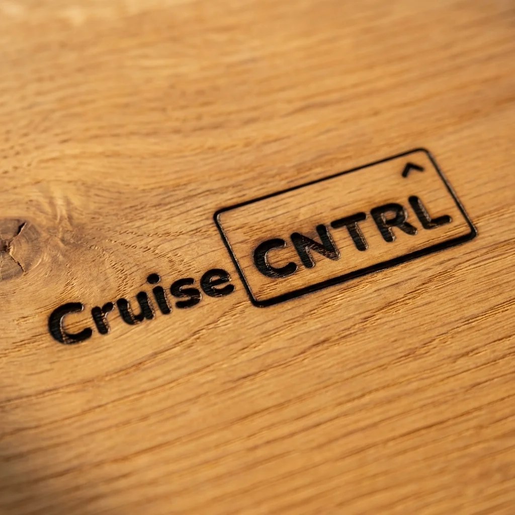 CruiseCNTRL logo burned into oak — brand identity applied on real-world material
